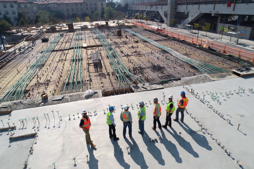 Construction workers wearing protective equipment standing at a construction site